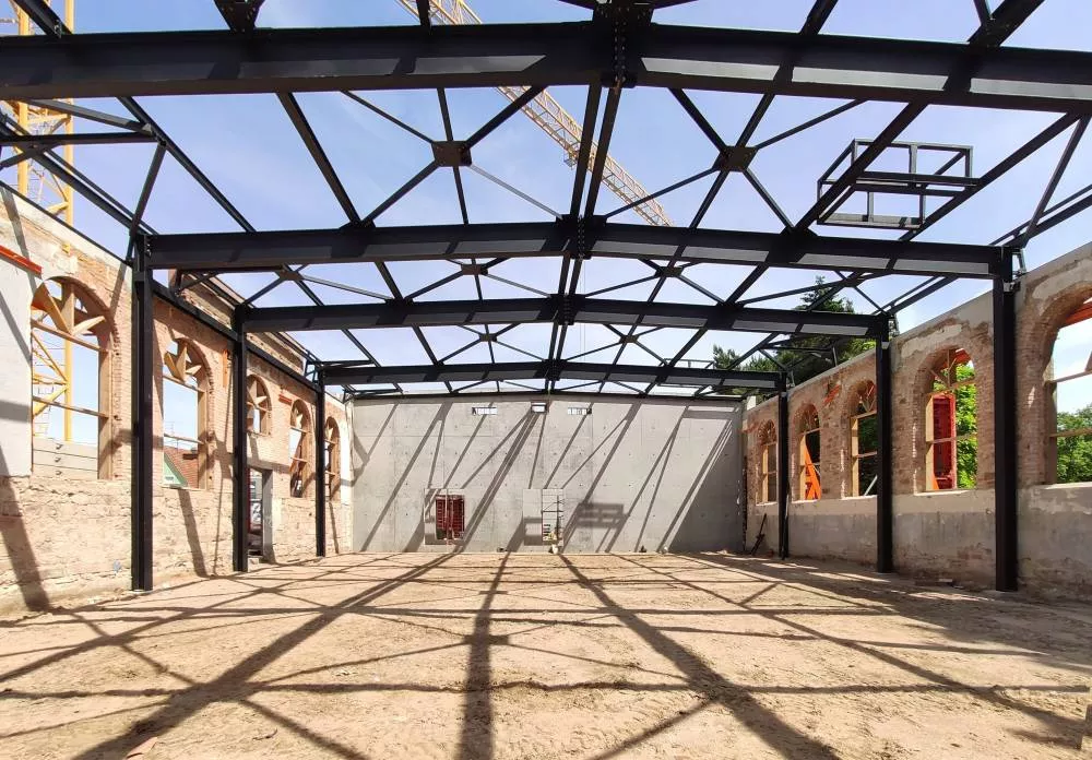 Crédit photo BALLAST Architectes : Salle de gymnastique avec portiques métalliques et sous-face bois